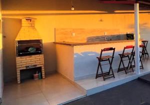 a model of a kitchen with a stove and stools at Casa com piscina e garagem privativa in Barra do Garças