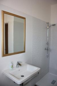 W białej łazience znajduje się umywalka i lustro. w obiekcie Apartments Mirela w mieście Novigrad