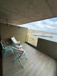 a balcony with a chair and a table and a view at HOM l Estudio con Vista al mar 3PAX in Valparaíso