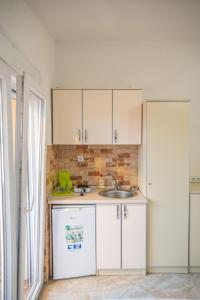 a kitchen with white cabinets and a sink at Ajka apartments in Ulcinj