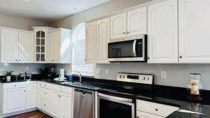 a kitchen with white cabinets and black counter tops at Beautiful duplex in Murrells Inlet B in Myrtle Beach