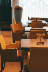 a row of tables and chairs with a vase of flowers at Virgo Hotel & Spa in Las Lenas +73 photos
