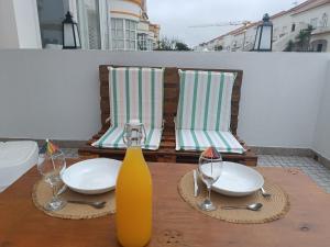 a wooden table with two chairs and a yellow vase at Bal&Bal in Baleal