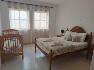 a bedroom with a bed with a crib and two windows at Bal&Bal in Baleal +24 photos