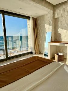 a bedroom with a large window with a view of the ocean at Aporte Hotel Cesme in Çeşme +44 photos
