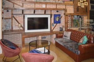 een woonkamer met een bank, stoelen en een tv bij Palacio de Congresos by My Home in Salamanca in Salamanca