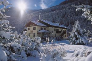 a house in the snow with snow covered trees at Rosengarden Alpine Residence in Valdidentro