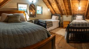 een slaapkamer met 2 bedden in een tiny house bij Secluded Creekside Cabin Hot Tub and Fire Pit in Cosby +12 foto's