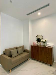 Una sala de estar con un sofá y un espejo. en Shi House- Studios BE5 - Swimming Pool & Balcony, en Long Bình