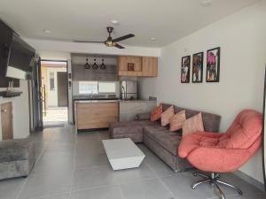 a living room with a couch and chairs and a kitchen at Espectacular casa, piscina privada- Ricaurte in Ricaurte