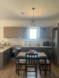 kuchnia ze stołem i krzesłami oraz kuchnia z niebieskimi szafkami w obiekcie panorama apartment w mieście Agia Fotia