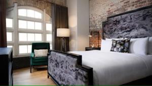 a bedroom with a large bed and a brick wall at JW Marriott Savannah Plant Riverside District in Savannah