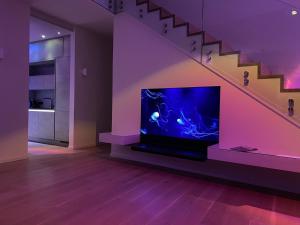 un salon avec une télévision à écran plat située sous les escaliers dans l'établissement Ferienhaus Villa Maparenii Olpenitz, à Olpenitz 40 autres photos