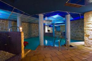 a swimming pool with blue lighting in a building at Hotel Spa Villa de Mogarraz in Mogarraz