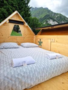 a bedroom with a large bed in a wooden house at StarsBOX - La Vrata Gialla in Montemaggiore
