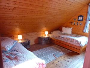 a bedroom with two beds in a log cabin at Wild West Lodge 48 Western-Feeling im Harz in Hasselfelde