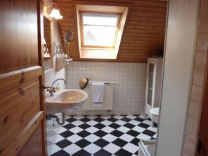 a bathroom with a sink and a black and white checkered floor at Wild West Lodge 48 Western-Feeling im Harz in Hasselfelde +19 photos