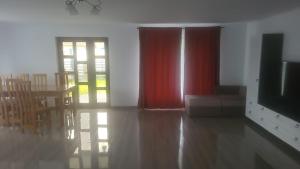 a living room with a red curtain and a table and chairs at Casa Serrena in Muşeteşti