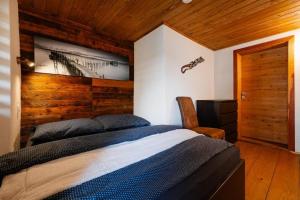 a bedroom with a bed and a wooden wall at VILLA Ružiná in Divín