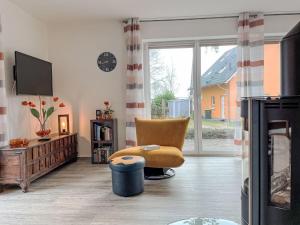 a living room with a chair and a television at Holiday Home Müritz Ferienpark Röbel-62 by Interhome in Röbel