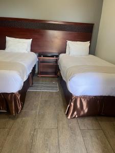 Dos camas una al lado de la otra en una habitación. en Tlou- Sejie Hotel, en Palapye