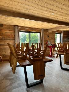 a room with wooden chairs and tables in a cabin at La Chênaie - Vue imprenable, pêche & grands événements in Roye