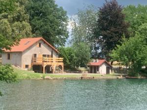 a house next to a lake with a house at La Chênaie - Vue imprenable, pêche & grands événements in Roye