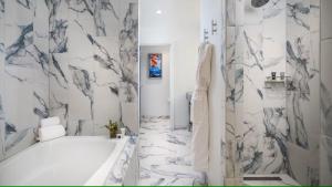 a white bathroom with a tub and a marble wall at JW Marriott Savannah Plant Riverside District in Savannah