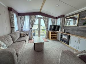 洛斯托夫特Homely Caravan With Decking And Wifi In Lowestoft Ref 12097B的带沙发和电视的客厅