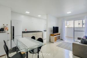 a living room with a glass table and a television at Apt c/ Churrasq. a 600m da Praia GEN0102 in Balneário Camboriú