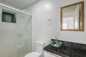 a bathroom with a toilet and a sink and a mirror at Apt c/ Churrasq. a 600m da Praia GEN0102 in Balneário Camboriú +17 photos