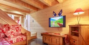 a living room with a tv in a log cabin at Gite Les Tarines 2 in Beaufort