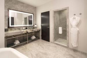 a bathroom with a shower and a sink and a mirror at JW Marriott Savannah Plant Riverside District in Savannah +37 photos