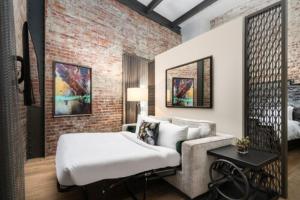 a living room with a bed and a couch at JW Marriott Savannah Plant Riverside District in Savannah