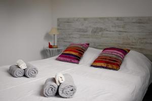 Una cama blanca con toallas y almohadas. en La CASADOLCE, en Porto Vecchio