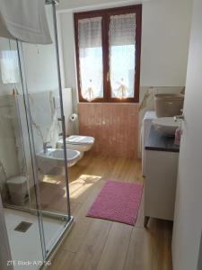 a bathroom with a glass shower and a toilet at Casa Vacanze La Favola Rosa sul Lago di Varese in Gavirate +24 photos