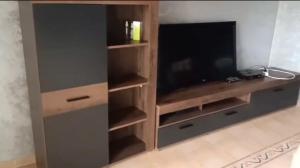 a living room with a entertainment center with a flat screen tv at Appartement Charmant et familiale in Saidia 