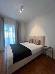 a bedroom with a large white bed and a window at inluz apartment in Vila do Conde +5 photos
