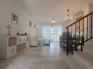 Una sala de estar con una mesa y un comedor. en Nerja Sun Apartments Casa Cipreses 4, en Nerja