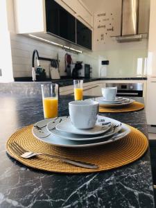 a table with two plates and two glasses of orange juice at Apartment Tashi, Korzo - Rijeka, 2 bedrooms in Rijeka