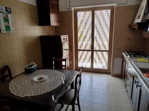 een keuken met een tafel en een tafel en een raam bij STELLA MARINA a 10 minuti dal mare in Formia +9 foto's