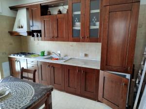 een keuken met houten kasten en een spoelbak bij STELLA MARINA a 10 minuti dal mare in Formia