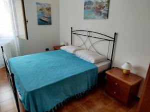 een kleine slaapkamer met een bed met een blauwe deken bij STELLA MARINA a 10 minuti dal mare in Formia
