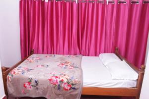 a bed in front of a pink curtain at SUNSHEE COFFEE PLANTATION HOMESTAY VILLA Madikeri in Madikeri