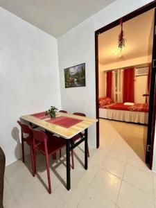 a dining room with a table and a bedroom at Urban Deca Staycation in Manila by April & Ivan in Manila
