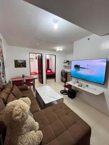 a teddy bear sitting on a couch in a living room at Urban Deca Staycation in Manila by April & Ivan in Manila