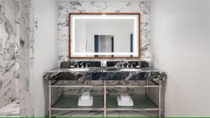 a bathroom with two sinks and a mirror at JW Marriott Savannah Plant Riverside District in Savannah