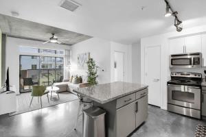 a kitchen and living room with a stove and a couch at Centric 2BR In HEART of DTPHX Free Garage Parking in Phoenix