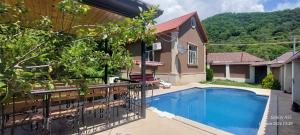 a house with a swimming pool in a yard at Qəbələ Vəndam in Gabala