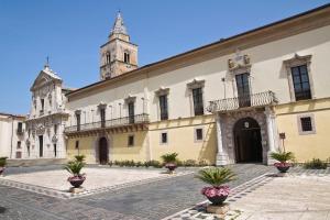 a building with a clock tower and a church at Ai piedi della collina in Melfi